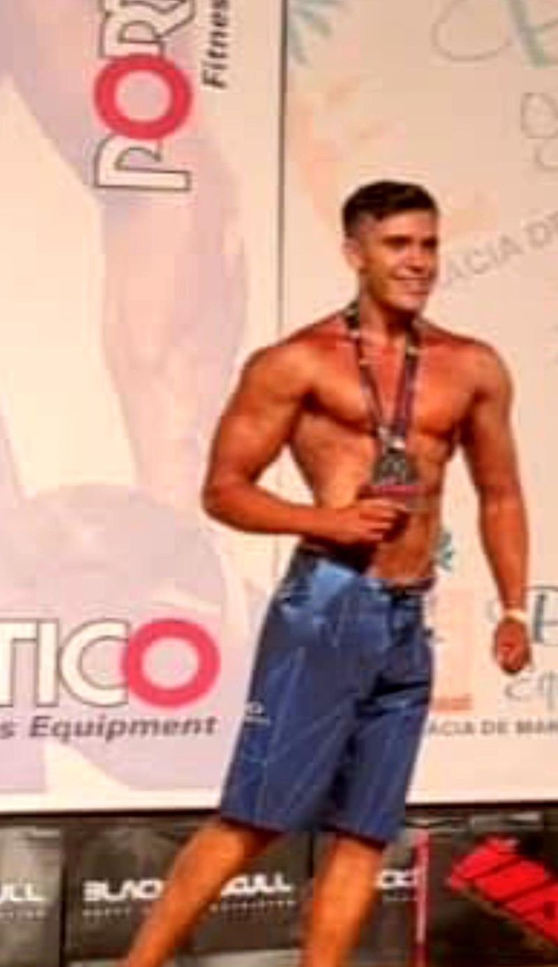 Matheus Altheia, natural Men's Physique champion, on stage with his medal